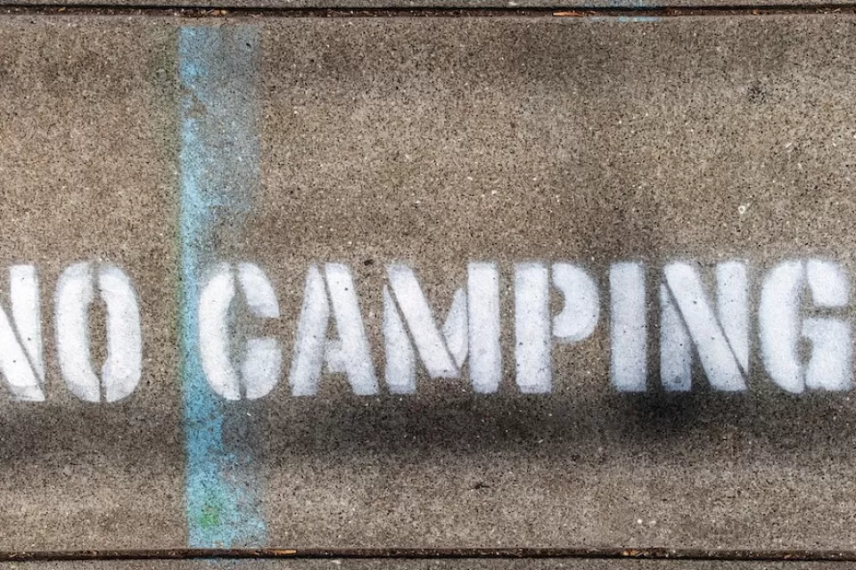 "No Camping" stencil on concrete.